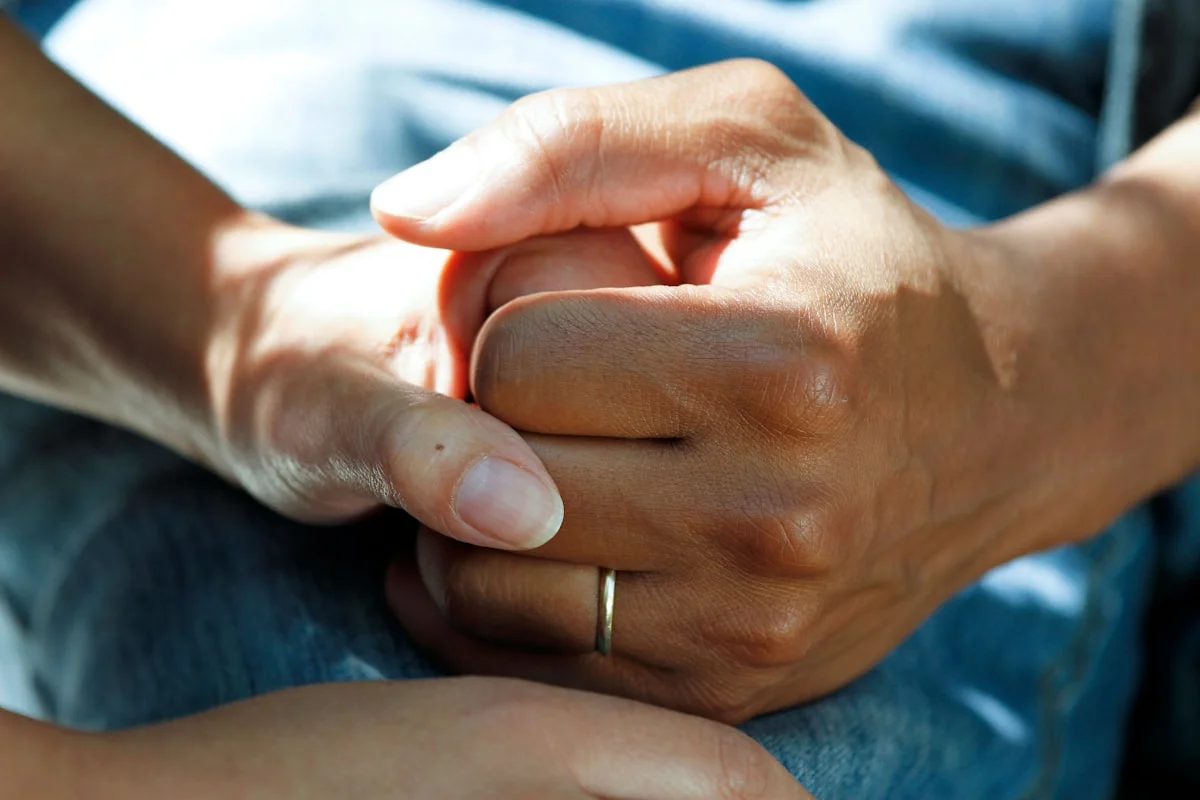Hands held tenderly — compassionate comfort and presence