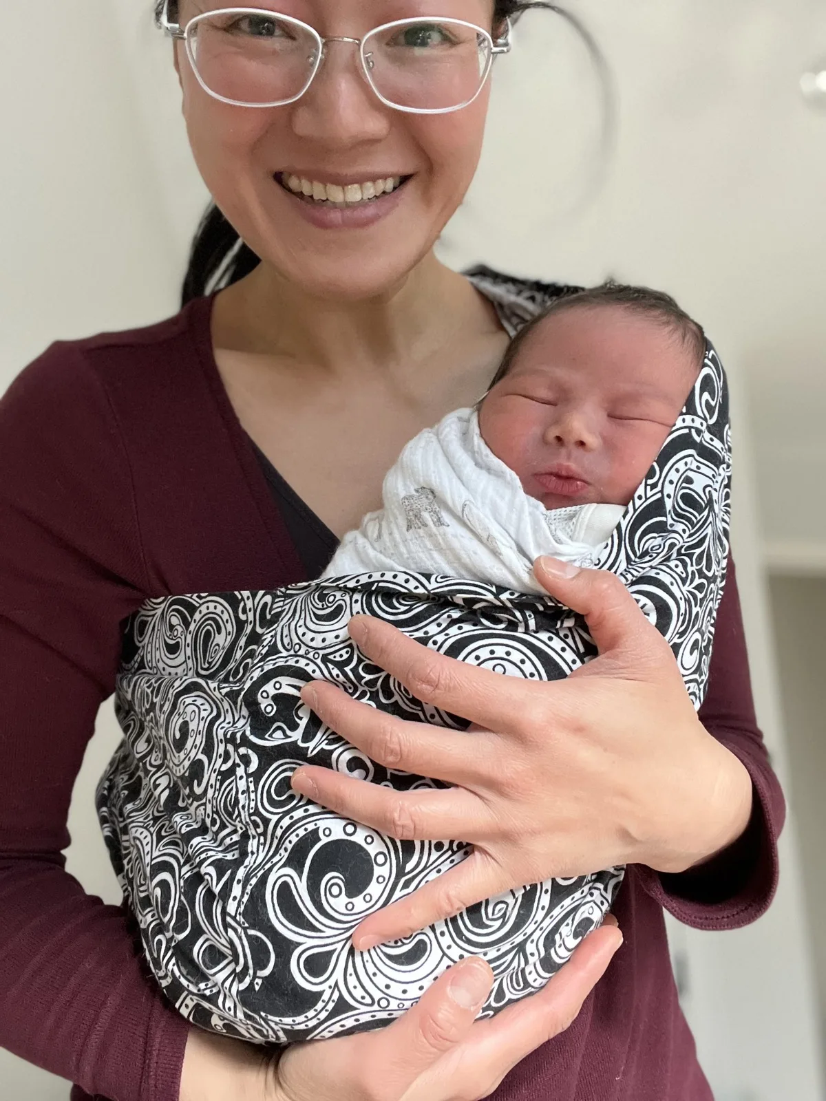 Dr. Lily Yu Gillespie holding a swaddled newborn — gentle postpartum recovery